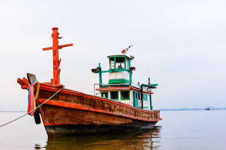 Old fishing boat with cloudy skyの写真素材