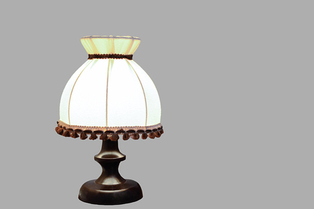 Old wooden desk lamp isolated on a gray background with a light bulb turned onの写真素材