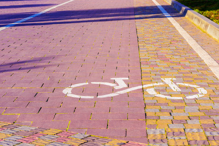 Bicycle route sign on the pavement in sunlight in a park. The ecological mode of transport. The decrease air emissions.の写真素材