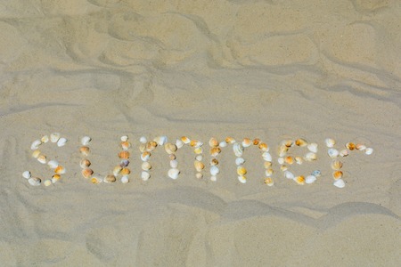 The inscription Summer is laid out from shells on the sandの写真素材
