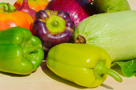Different peppers, zucchini, tomatoes, onions on a wooden boardの写真素材