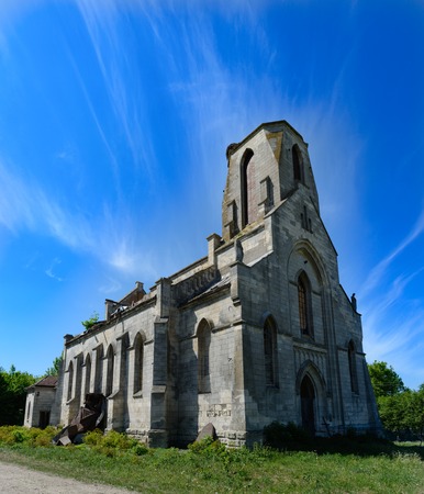 MYL'NE, TERNOPIL REGION, UKRAINE 12 MAY 2018: An old Catholic church that is not used and is abandoned to the backgrounds of a blue sunny sky with clouds. It was used as a storage facility for chemical fertilizers in the time of the USSR.のeditorial素材