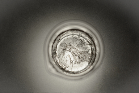 Chemical glass with crystals of salicylic acid on a matte glass with backlighting from belowの写真素材