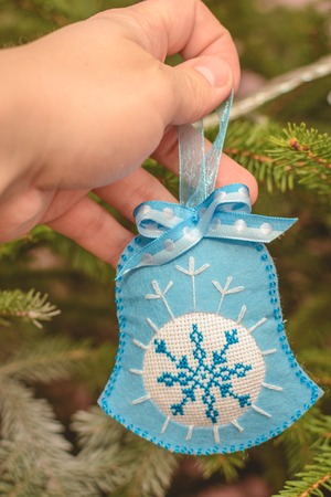 Owned Christmas tree decoration on a branch of a Christmas tree and a blue orange layer.の写真素材