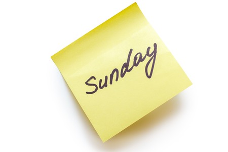 A yellow piece of paper for the notes with a Sunday inscription is isolated on white.の写真素材