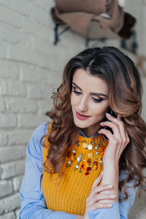 Portrait of a Girl is talking on the phone. Good and positive emotions overwhelmed herの写真素材