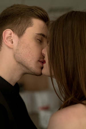 Portrait of beautiful young man and woman dressed in classic clothes, studio shot over grey background. Sexy passion couple in love.の写真素材