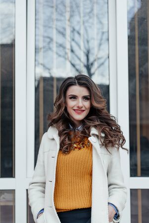 Outdoor lifestyle portrait of pretty young girl posing on stairway, wearing in casual style with sunglasses on urban background.の写真素材