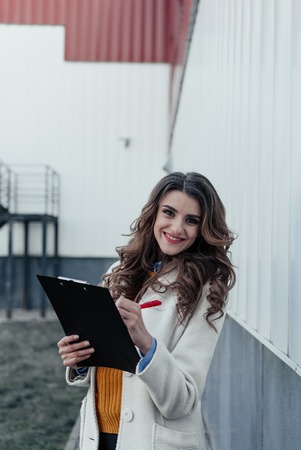 Serious business woman with tablet pc in front of office buildingの写真素材