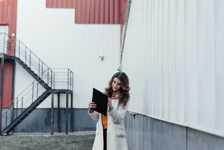 Serious business woman with tablet pc in front of office buildingの写真素材