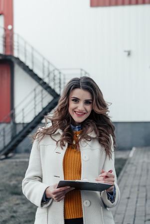 Serious business woman with tablet pc in front of office buildingの写真素材