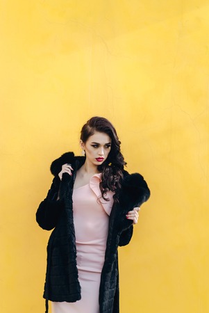 Girl in winter clothes model looks. Posing for the cameraの写真素材