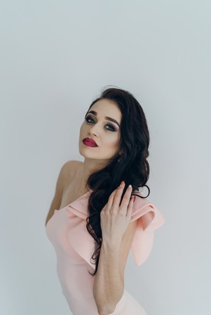 Beautiful young fashionable woman posing in pink dress, smiling, looking at camera. Vogue Styleの写真素材