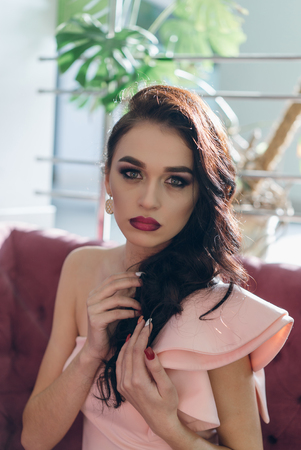 Beautiful young fashionable woman posing in pink dress, smiling, looking at camera. Vogue Styleの写真素材