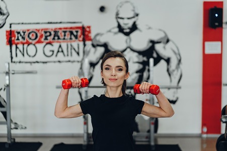 Strong woman weightlifting at the gym looking happy