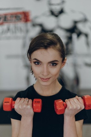 Strong woman weightlifting at the gym looking happy