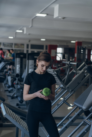 She holds a shaker with sports nutritionの写真素材