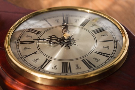 Antique clock with Roman numerals and a beautiful face. Watches are decorated with noble woodの写真素材