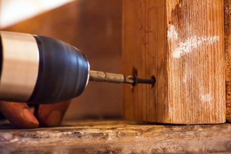 Man Screwing a screw into the woodの写真素材