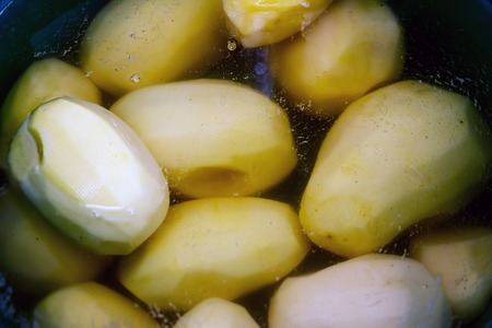 Peeled potatoes in waterの写真素材