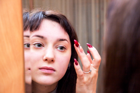 Girl looking into mirrorの写真素材