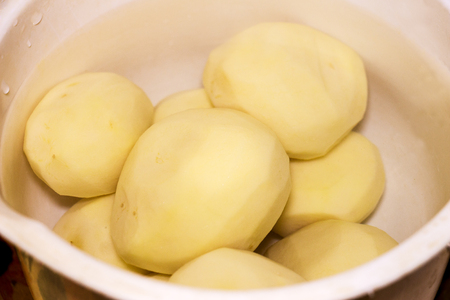 Peeled potatoes in waterの写真素材