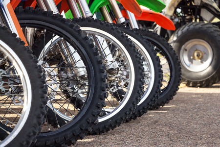 Motocross bike stand in a row. Motocross tires and wheels