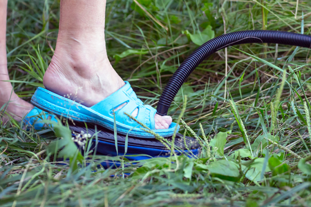 The woman pumping her inflatable mattress with foot pumpの写真素材
