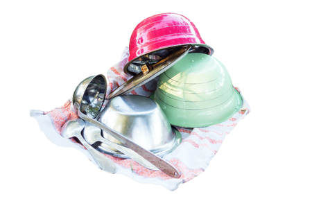 Kitchen utensils on a towel on white background. On the towel are plates, a ladle and spoonsの写真素材