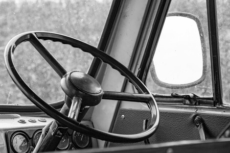 The steering wheel in the cockpit of an old car. Retro style. Black and white photoの写真素材