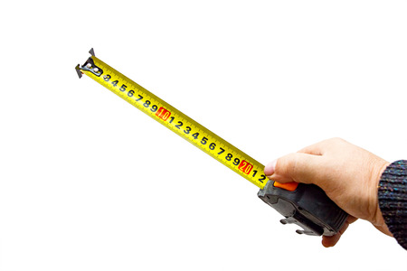 Measuring tool. Hand with a tape measure isolated on white backgroundの写真素材