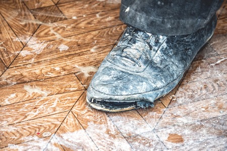 Old dirty ripped shoes clad on footの写真素材