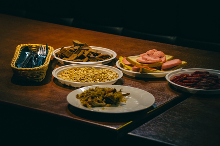 Plates with food on the table in a dark roomの写真素材