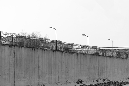 Fence with barbed wire, place of detention, prison. Black and white photoの写真素材