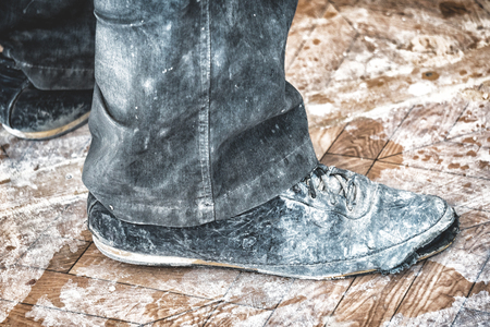 Old dirty ripped shoes clad on footの写真素材