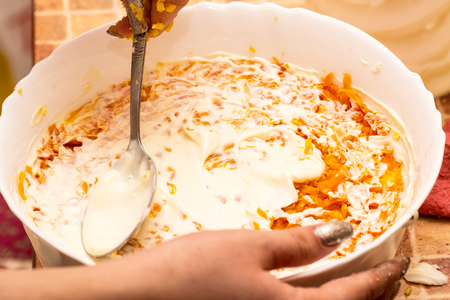 Add mayonnaise, sour cream in salad and stir with a spoon. Selective focusの写真素材