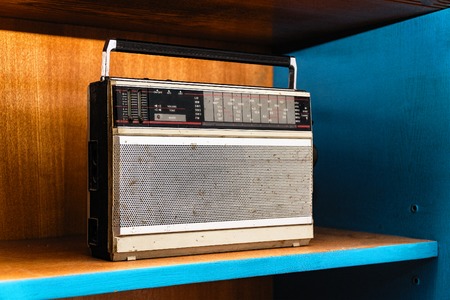 Old vintage dirty analog radio on wooden shelfの写真素材