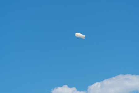 Large white air balloon in the shape of an airship in the blue skyの写真素材