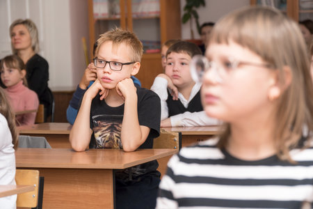 CHAPAEVSK, SAMARA REGION, RUSSIA - OCTOBER 24, 2018: A schoolboy with glasses in the classroom is listening to the teacher. Portrait of an unfamiliar schoolboy with glasses. Selective focusのeditorial素材