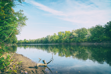 River or lake in early autumn in the forest. Landscape in early autumnの写真素材