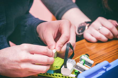 The boy makes a car model from the details of the children's designer
