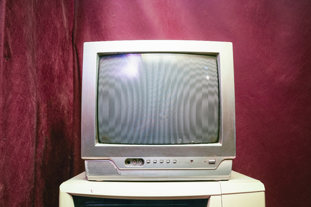 Old analog TV with kinescope on a red backgroundの写真素材
