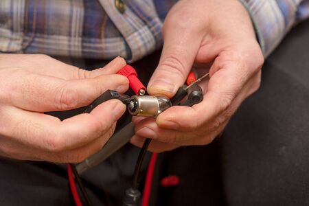 A male engineer checks a light bulb for efficiency with the help of multimeter probes.の写真素材