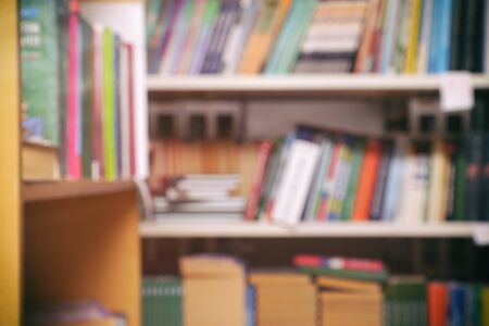 Blurred image - books on the shelves in the library