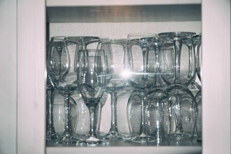 Clean empty wine glasses on the shelf in the cupboard. Soft focusの写真素材