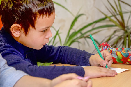 Chapaevsk, Samara region, Russia - October 15, 2019: A schoolboy sitting at a desk writes on a sheet of paper. Soft focus. Selective focusのeditorial素材