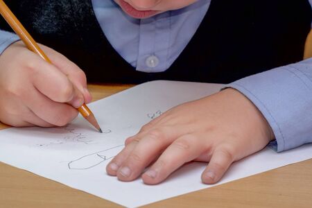 Boy draws a pencil on a piece of paper