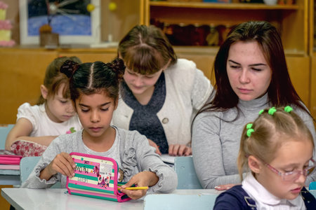 Chapaevsk, Samara region, Russia - October 15, 2019: Schoolgirl at a desk with a woman teacher. The teacher is engaged with a primary school Schoolgirl. Selective focusのeditorial素材