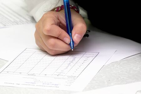 A woman fills out or signs a document or applicationの写真素材