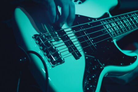 A man plays bass guitar on stage. Hand close-up. Soft focusの写真素材